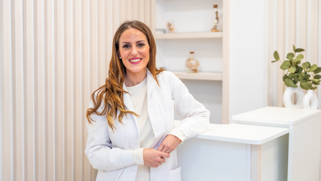 Aesthetic doctor in aesthetic clinic reception with welcome smile at Battersea Power Station for a clients first visit.