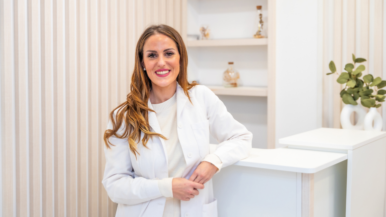 Aesthetic doctor in aesthetic clinic reception with welcome smile at Battersea Power Station for a clients first visit.